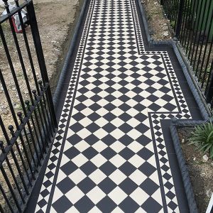 victorian black and white floor tiles leading from the gate to the front door of a brick house